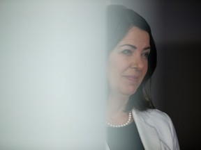 Premier Danielle Smith stands in a doorway as she participates in a press conference at a new transitional bed facility referred to as the Bridge Healing Transitional Accommodation Program, 16022 100 Ave., in Edmonton Thursday, Jan. 12, 2023.