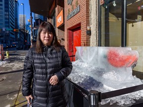 Anissa Wong, secretary of Chinatown BIA, poses for a photo with the ice sculpture in display outside Silver Dragon restaurant in Chinatown that was vandalized and knocked down on Friday evening.