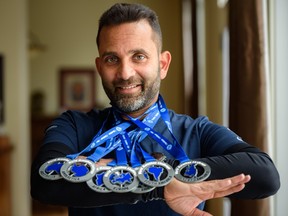 Munish Mohendroo displays his medals in his home in Calgary on Monday after completing the World Marathon Challenge - seven marathons on seven continents in seven days.