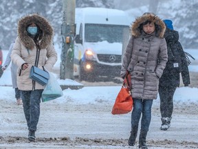 Calgarians walk amid storm surge after heavy overnight snow in Calgary on Tuesday, February 21, 2023.