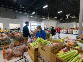 Volunteers put together a hamper of fresh and canned foods at the Calgary Food Bank on Wednesday, October 26, 2022.