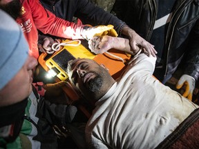 Rescuers carry Ilhan Gunes, 45, survivor at the site of a building that collapsed after 42 hours of the earthquake on February 7, 2023 in Hatay, Turkey.