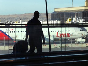 An airline passenger passes the new Lynx Air Boeing 737 on the tarmac at Calgary International Airport on Thursday, April 7, 2022 in Calgary.