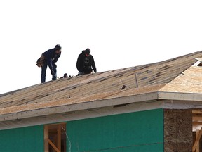 Workers are shown on Thursday, Feb. 16, 2023, on new home construction in the southwest Calgary community of Aspen.