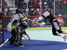 CALGARY, AB - FEBRUARY 10, 2023: Calgary Roughnecks transition Zach Currier scores a diving goal on Saskatchewan Rush goalkeeper Alex Burque during in NLL action at the Scotiabank Saddledome last night. The Roughnecks defeated the Rush 13-6.  Angela Burger/Calgary Roughnecks