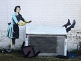 An artwork, acknowledged to by street artist Banksy, is pictured on the side of a house in Margate, south east England on February 14, 2023. - The artwork appears to show a a 1950s housewife with a swollen eye, missing a tooth, and apparently shutting a man in a freezer. The freezer was later removed by council workers.