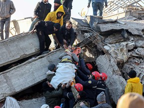Rescue workers pull out a survivor from the rubble of a destroyed building in Kahramanmaras, southern Turkey, a day after a 7.8-magnitude earthquake struck the country's southeast, on February 7, 2023. Rescuers in Turkey and Syria braved frigid weather, aftershocks and collapsing buildings, as they dug for survivors buried by an earthquake that killed thousands of people. Some of the heaviest devastation occurred near the quake's epicentre between Kahramanmaras and Gaziantep, a city of two million where entire blocks now lie in ruins under gathering snow.