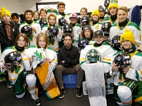 Chris Snow, centre, with son Cohen, behind, and U13 Gold Northstar’s teammates are participating in a sticker campaign to fundraise for ALS in Calgary on Saturday, February 25, 2023.