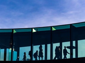 Office workers walk through a Plus 15 into The Bow office building in downtown on Wednesday, January 18, 2023.