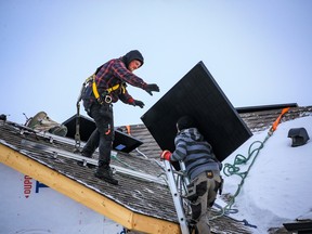 Workers with SkyFire Energy install solar panels on a home in Belmont in southwest Calgary on Thursday.