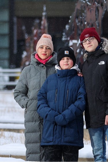 Viktoriia Karman and her two sons Andrii, 12, and Oleksandr, 16 pose for a photo in downtown Calgary on Monday, Feb. 20, 2023. The family fled from Ukraine after Russia invaded the country on Feb. 24, 2022.
