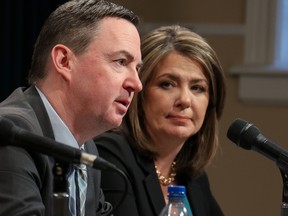 Premier Danielle Smith listens as Health Minister Jason Copping answers questions about the work underway to reduce wait times and improve patient care in Alberta during a press conference at the McDougall Centre in Calgary on Monday, Feb. 27, 2023.