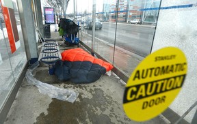 A man lies in a bus shelter near 12th Street and 16th Avenue NW on Thursday, January 12, 2023. He was conscious and refused help from the Downtown Outreach Addiction Program (DOAP) team. All doors on the shelter were intact and working.