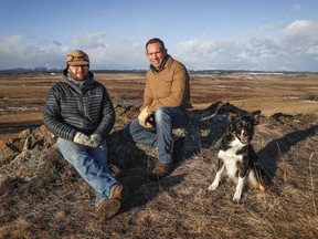 Justin Thompson, right, executive director of the Southern Alberta Land Trust, landowner Matt Kumlin and Kumlin's dog, Newt, look out over ranchland west of Cochrane, Alta., Friday, Feb. 10, 2023.