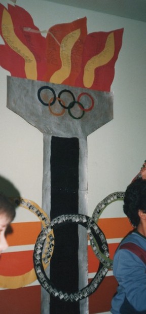 This photo, also submitted by Janet Wees, shows an artwork created by the Young Olympians at Buchanan School in 1988, which lists the names of all the school students on the flames and shows photos of the students on the bottom set of rings.