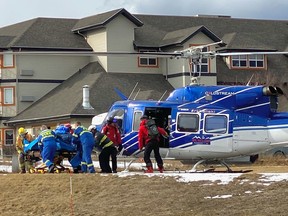 Rescue and medical personnel unload a patient from an RK Heliski helicopter at Invermere District Hospital. It was one of a half-a-dozen flights to bring people down the from the site of an avalanche that killed three and injured four people during a day of heli-skiing in mountains above Invermere on March 1, 2023.