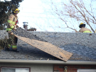 Calgary firefighters remove debris from trees and rooftops as Investigators comb through the rubble at the scene of an explosion on Maryvale Way NE in Calgary on Monday, March 27, 2023. At least 10 people were injured in the blast.