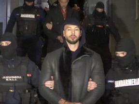 In this grab taken from video released by Observator Antena 1, Social Media personality Andrew Tate is led away by police, in the Ilfov area, north of Bucharest, Romania, Thursday, Dec. 29, 2022.