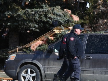Investigators walk by debris at the scene of an explosion on Maryvale Way N.E. in Calgary on Monday, March 27, 2023.