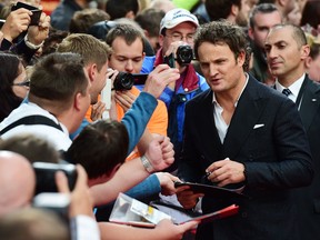 Australian actor Jason Clarke , right, signs autographs upon arrival for the European premiere of the film Terminator Genisys on June 21, 2015 in Berlin. The actor will star in the Calgary-shot thriller Wind River: The Next Chapter.
