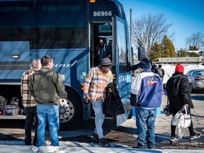 Migrants exit a bus in Plattsburgh, New York, where taxi drivers wait to take them to the Canadian border at Roxham Road.