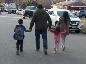Parents walk with children outside Richneck Elementary School, where according to the police, a six-year-old boy shot and wounded a teacher, in Newport News, Va., Jan. 6, 2023, in this screen grab from a handout video.