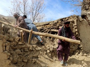 Residents clear debris from a damaged a house at Sooch village in Jurm district of Badakhshan Province on March 22, 2023, following an overnight earthquake.