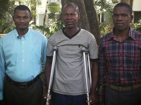 In this photograph provided by attorney Ela Matthews, David Boniface, Nissage Martyr and Juders Yseme, from left, pose together in January 2014, in Haiti. Boniface, Yseme and Martyr's son Nissandere are plaintiffs in a suit against former Les Irois, Haiti Mayor Jean Morose Viliena, who now lives in suburban Boston. The former mayor is accused of terrorizing his political opponents in a case that highlights the violent nature of Haiti's politics and the lack of accountability. The trial begins Monday, March 13, 2023, in federal court in Boston.