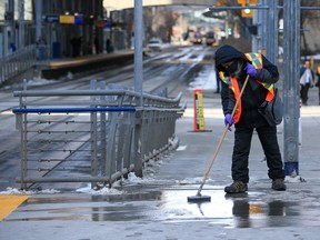 A worker cleans up blood at the 4th Street S.W. CTrain station after an early morning multiple stabbing incident on Wednesday, March 15, 2023.