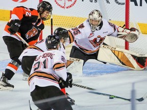 Calgary Hitmen goaltender Brayden Peters stretches across the crease as the Medicine Hat Tigers attack at Scotiabank Saddledome in Calgary on Sunday, March 19, 2023.