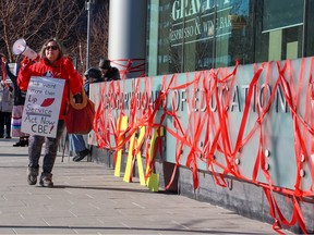 Protesters gathered outside the Calgary Board of Education building to call for an end to delays in changing the name of John A. Macdonald Junior High School and the mascot name for John G. Diefenbaker High School on Tuesday, March 21, 2023.