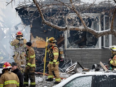 Firefighters attend the scene of a house explosion that injured several people, destroyed one home and damaged others in Calgary, Alta., Monday, March 27, 2023.