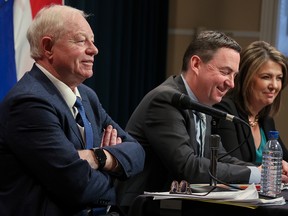 Dr.  John Cowell, left, appears with Health Minister Jason Copping and Premier Danielle Smith at a press conference in Calgary on February 27.