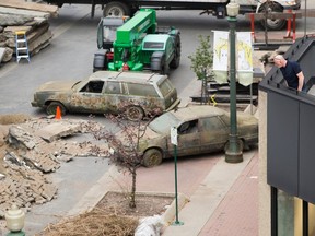 A man looks from an office building at the post-apocalyptic scene being created in Edmonton's Rice Howard Way as crews prepare for filming on the HBO series The Last of Us, Tuesday, Oct. 5, 2021.