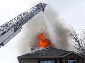 The Calgary Fire Department battles two homes on fire on Citadel Way N.W. in Calgary on Friday, March 24, 2023.