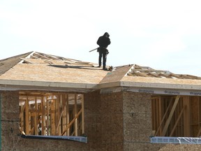 Workers are shown on new home construction in the southwest Calgary community of Aspen on Feb. 16.