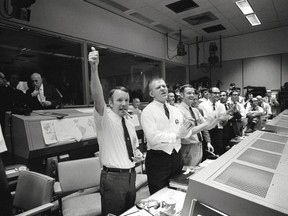 On this day in 1970, the Apollo 13 moon mission was cancelled after an on-board explosion. The three astronauts returned safely to earth four days later. Picutred, three of the four Apollo 13 Flight Directors applaud the successful splashdown of the Command Module Odyssey while Dr. Robert R. Gilruth, Director, Manned Spacecraft Center (MSC), and Dr. Christopher C. Kraft Jr., MSC Deputy Director, light up cigars (upper left). Postmedia archives.