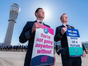 Capt. Tim Perry, ALPA Canada president, left, and Capt. Bernard Legal, chair of WestJet Master Executive Council, were photographed while a large group of WestJet pilots hold a picket outside WestJet campus in Calgary on Friday, March 31, 2023.