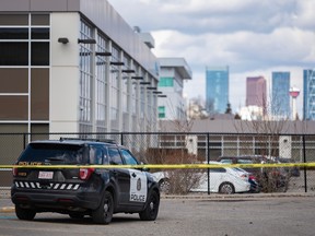Calgary police taped off an area in the parking lot of a commercial complex on 1 St. S.W. on Wednesday, April 12, 2023.