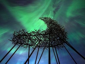 The northern lights provides a dramatic backdrop to the art installation Convergence in Rocky Ridge on Sunday, April 23, 2023.