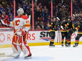 VANCOUVER, CANADA - APRIL 8: Cole McWard #48 of the Vancouver Canucks is congratulated after scoring his first NHL goal on Jacob Markstrom #25 of the Calgary Flames during the first period of their NHL game at Rogers Arena on April 8, 2023 in Vancouver, British Columbia, Canada.