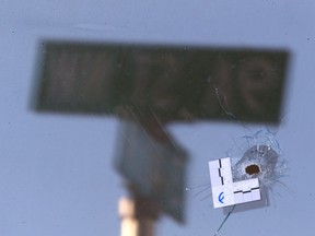 A street sign is reflected and a bullet hole is shown in the front window at a residence at 9A Street and 3 Avenue N.W. in Kensington on Thursday, April 13, 2023.