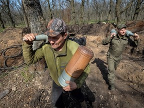 Ukrainian servicemen carry shells for a tank, as Russia's attack on Ukraine continues, near the front-line city of Bakhmut on April 10, 2023.