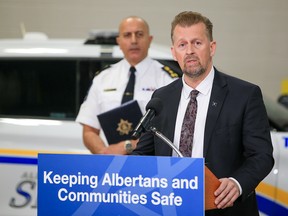 Public Safety Minister Mike Ellis announces the new fugitive detention unit on Tuesday. Behind him is Alberta Sheriff Chief Farooq Sheikh.