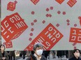 Pedestrians walk in front of a Uniqlo store operated by Japan's Fast Retailing in Tokyo.