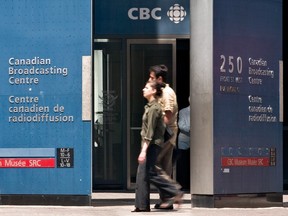 Pedestrians walk in front of the Canadian Broadcasting Corporation building in downtown Toronto. Canada's public broadcaster said April 17 it was effectively quitting Twitter over a new government-funded label it says questions its editorial independence.