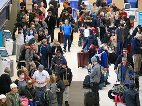 Hundreds of WestJet passengers line up as they wait to rebook cancelled flights at the Calgary International Airport on Dec. 20, 2022. Weather issues across Canada caused major delays at the airport.