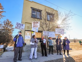 Members of the Millican Ogden Heritage Group rally outside the historic building at 7044 Ogden Road that they are hoping to save from demolition on Wednesday, April 5, 2023. The building, originally a Chinese laundry, has been slated for demolition as part of construction for the Green Line.