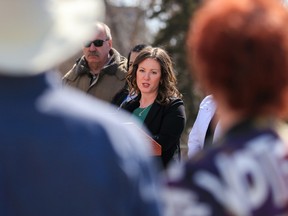 Crescent Heights residents stop and listen to Calgary-Shaw MPP Rebecca Schulz during a press conference on policing and crime in the province on Wednesday.