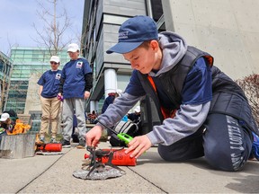 Connect Charter School students set up camp stoves to cook their lunches outside the SMART Technologies building on Wednesday, April 19. The building will soon become a hub for Connect students as well as several other charter schools in the city after it was recently approved by the province. Connect Charter School has an extracurricular education component as part of students' studies.